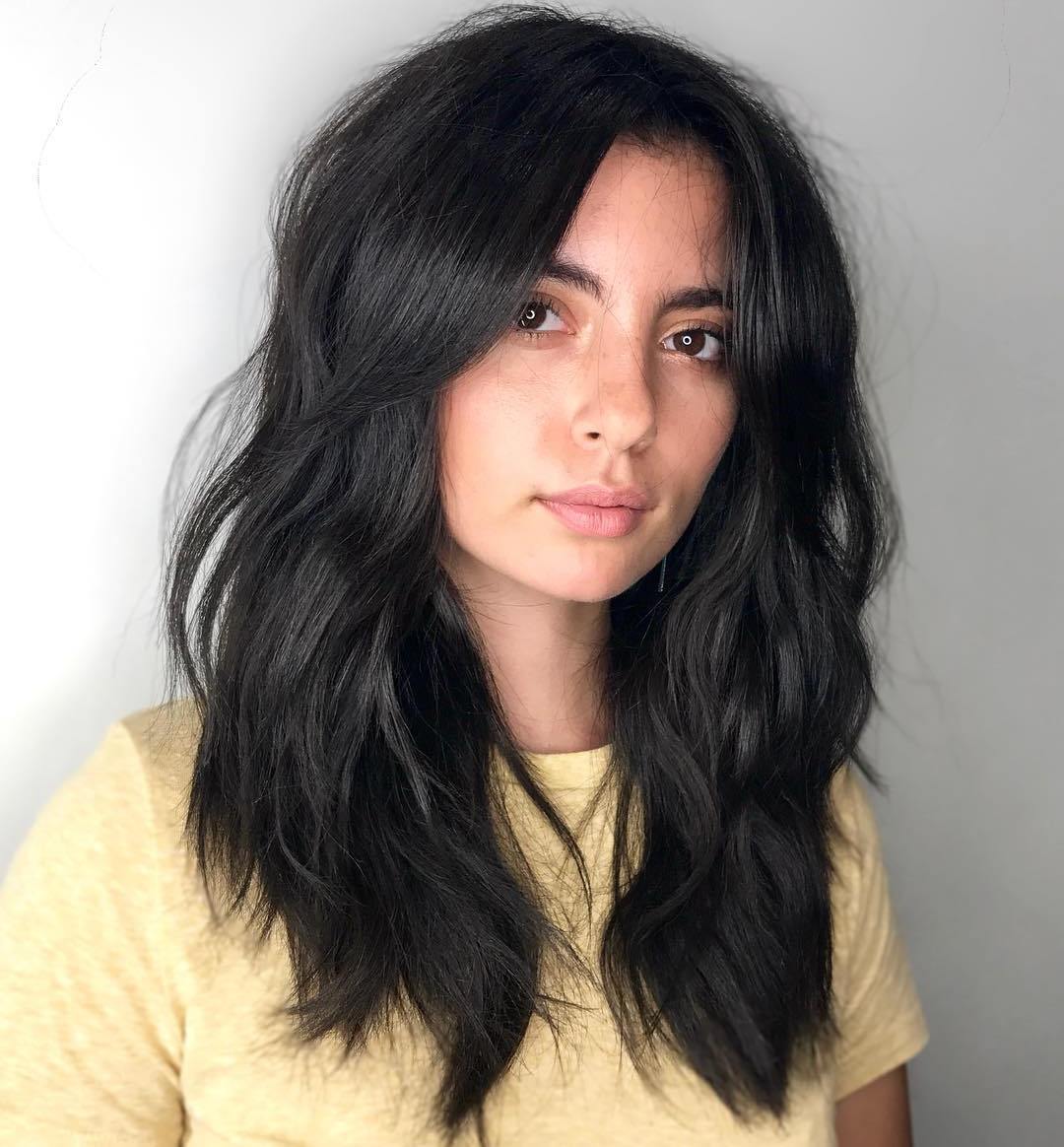 Beachy Layered Wavy Hairstyle with Bangs